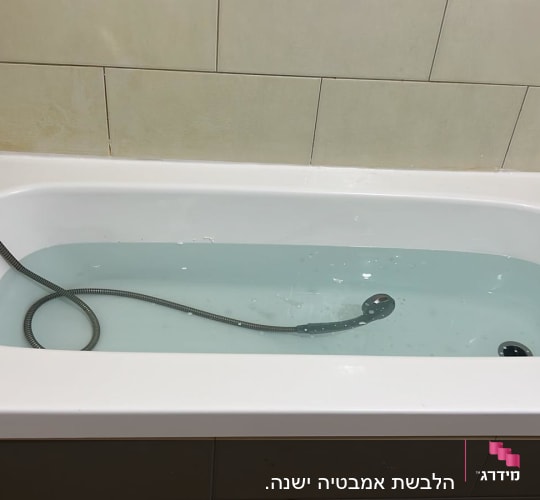 אמבטיה עם מים וצינור מתכת בתוכה